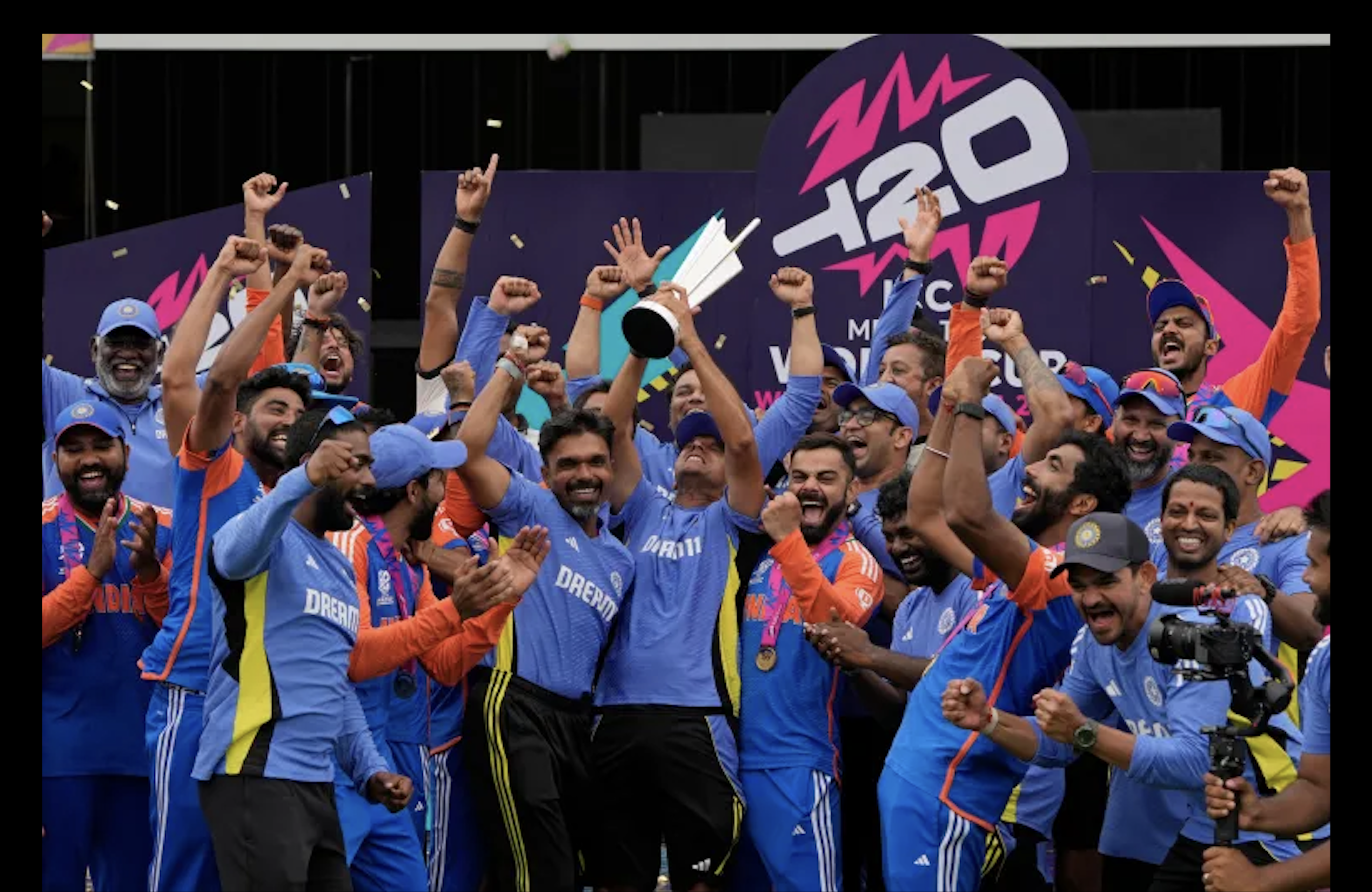 India's head coach Rahul Dravid, center, and Virat Kohli, center right, celebrate with players and team support staff with the winners trophy after defeating South Africa in the ICC Men's T20 World Cup final